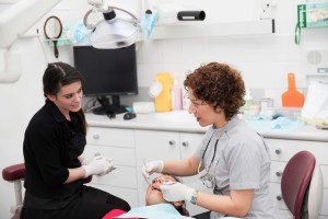 Dentist sitting with patient in chair