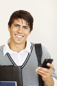 Smiling adult typing a text message on mobile phone